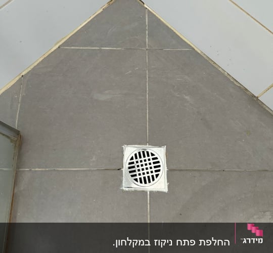 רצפת אריחים עם ניקוז עגול בפינה